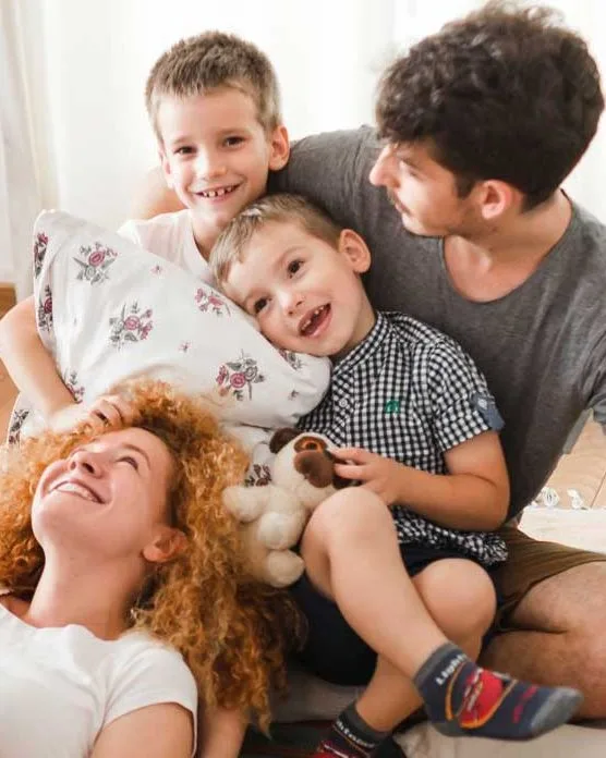 Why Choose Us-crop Family enjoying time together, smiling and playing in a cozy home setting, highlighting warmth and connection, relevant to property management's focus on family-friendly environments.