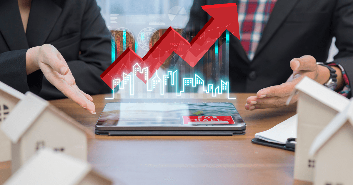Business professionals discussing real estate investment trends with a digital graph showing upward growth on a tablet, surrounded by miniature house models.