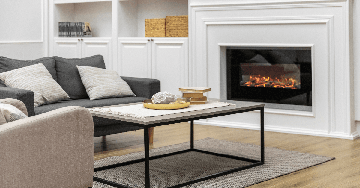 Cozy living room featuring a modern fireplace, stylish gray sofa with decorative pillows, and a minimalist coffee table with decorative items, highlighting interior design elements in home improvement renovations.
