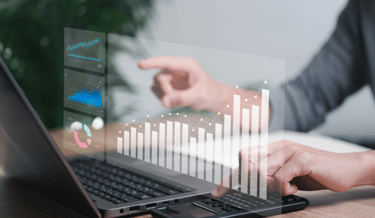 A laptop displaying overlaid graphs and charts representing financial data.