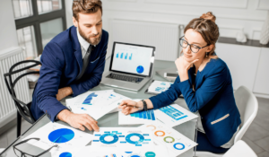 Two Property Managers are seated at a table reviewing graphs