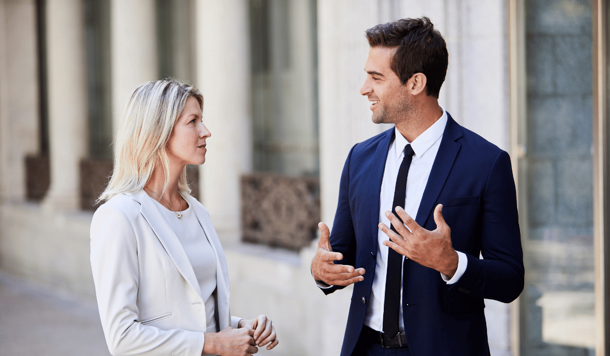 Two people in business attire are having a conversation