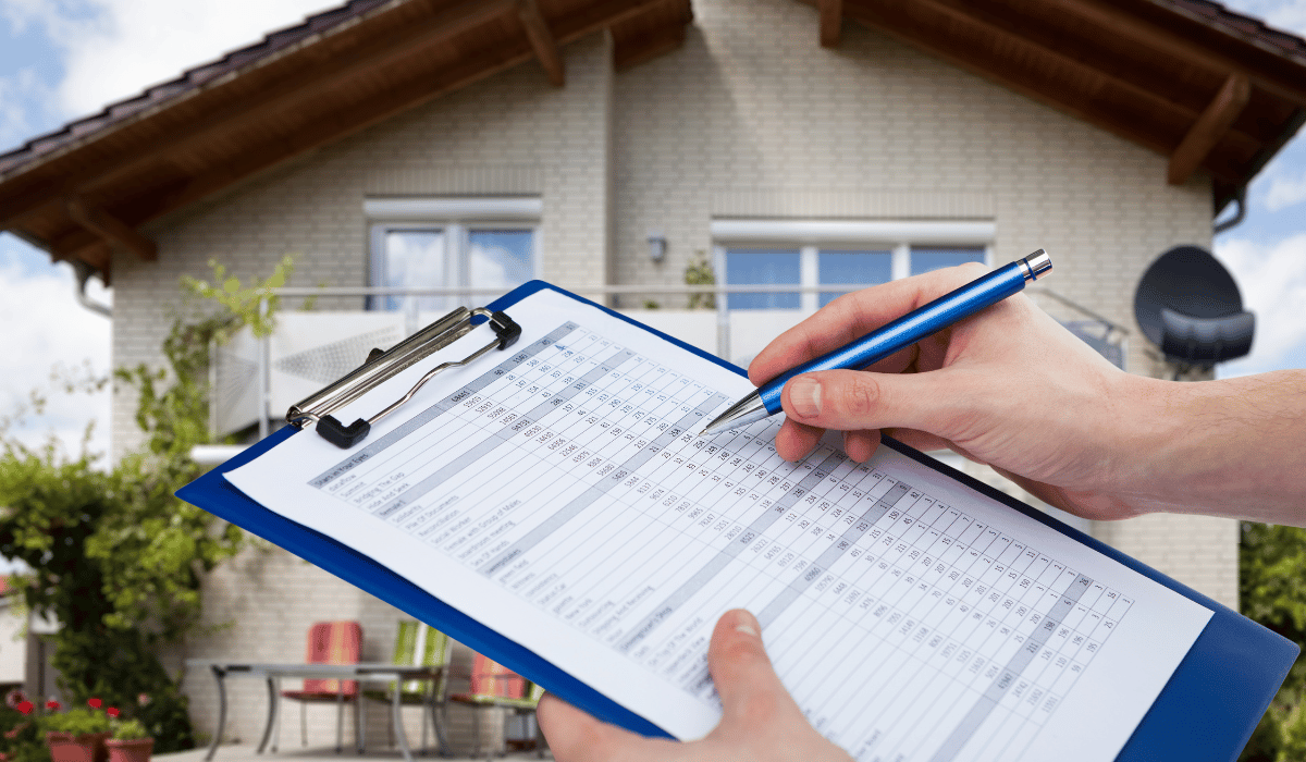 A property inspector holding a clipboard with a detailed document, likely a home inspection checklist.