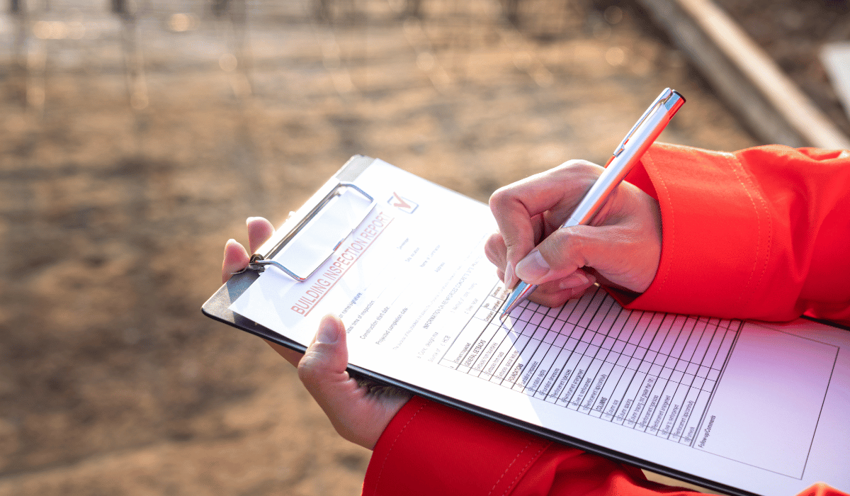 Home inspector writing on a building inspection report.