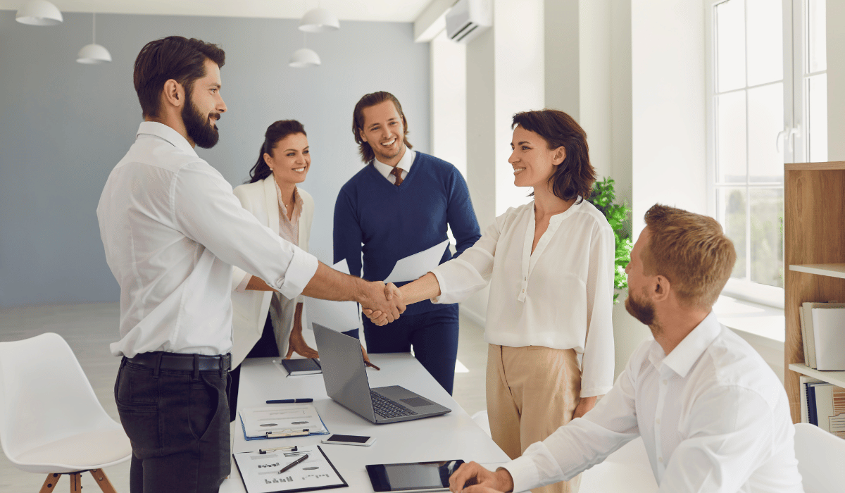 Businesspeople shaking hands across a table.