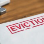 A mail envelope labeled eviction rests on a wooden table