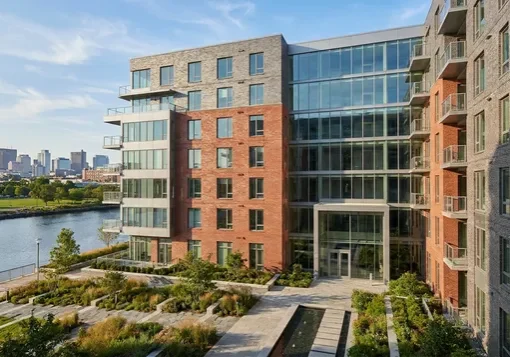 Modern waterfront condominium building near Assembly Square in Somerville, MA with the Boston skyline visible across the river
